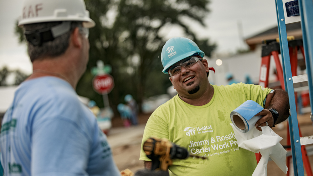 Benito laughs with Carter Work project volunteer on a build site