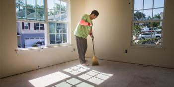 Homeowner sweeping her newly built house