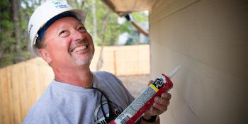 Volunteer lays caulk, DIY home repair and preventive maintenance checklist, Habitat for Humanity