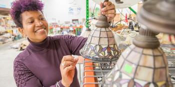 Woman with purple hair picking out a lighting fixture in a Habitat ReStore