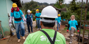A group of Global Village volunteers in Habitat shirts on a build site in Mexico.