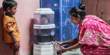 Woman getting water from a Dhaka water filter, Why is clean water important? Habitat for Humanity