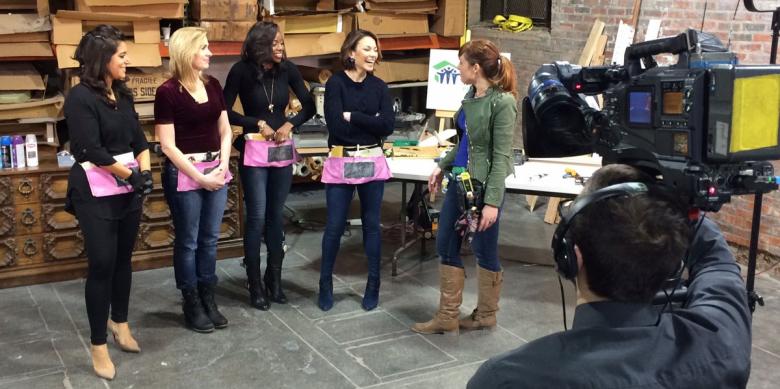 The hosts of FYI Philly receive canvas tool belts to hold their essential DIY tools