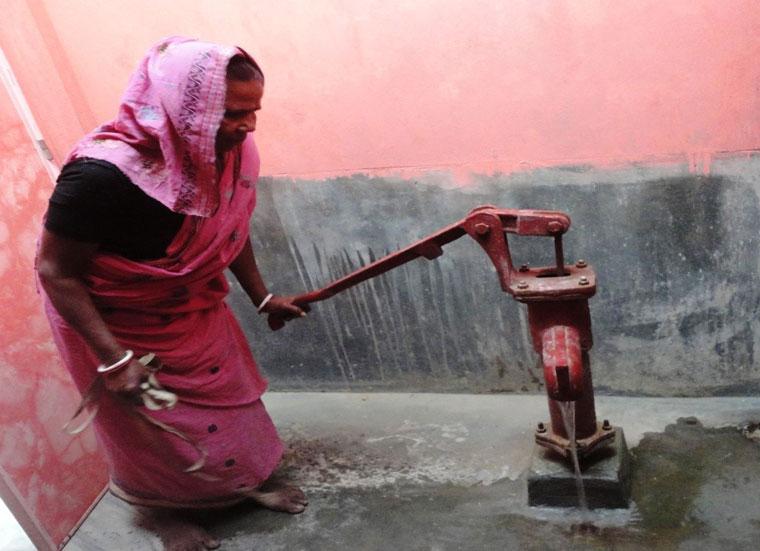 Woman with a water pump, Why is clean water important? Habitat for Humanity