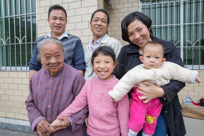 (Clockwise from top left): Zhimin, his father Yongchu, Zhimin’s wife Meiling with their youngest daughter Youyou and eldest daughter Xinyi, and his grandmother Nanjiao, in front of their Habitat house in Guangdong, China. Photo: Habitat for Humanity/Jason Asteros.