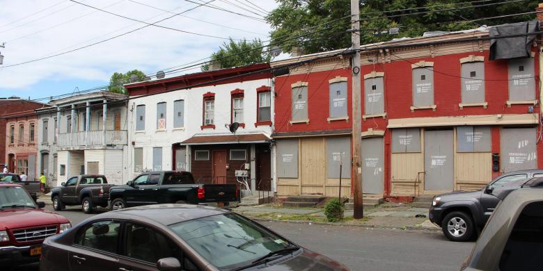 A block of attached townhomes that are in visible disrepair.