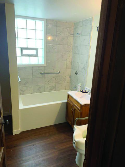 Clean bathroom with new tile, flooring, shower and cabinet.