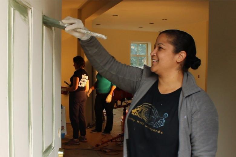 Nilda painting the door of her Habitat house.