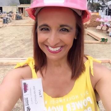 Volunteer Teri on a Habitat build site wearing a pink hardhat.