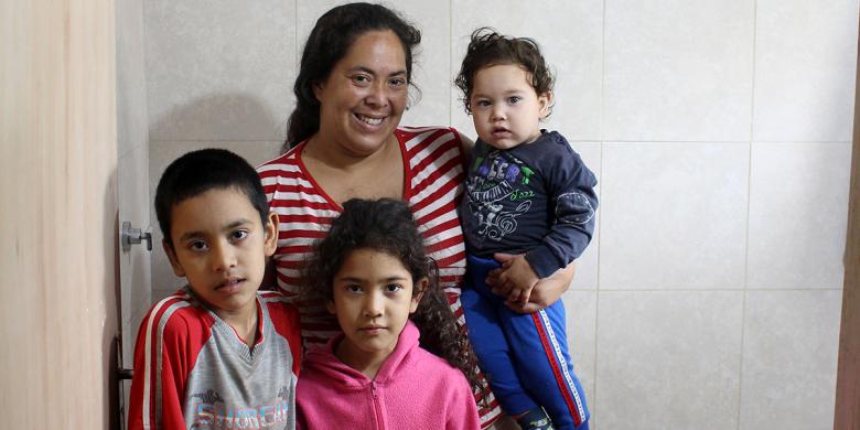 Mirtha y sus hijos Ezequiel, Magali y Elías en el nuevo baño de su casa. / © Hábitat para la Humanidad Paraguay, Lourdes Benitez.