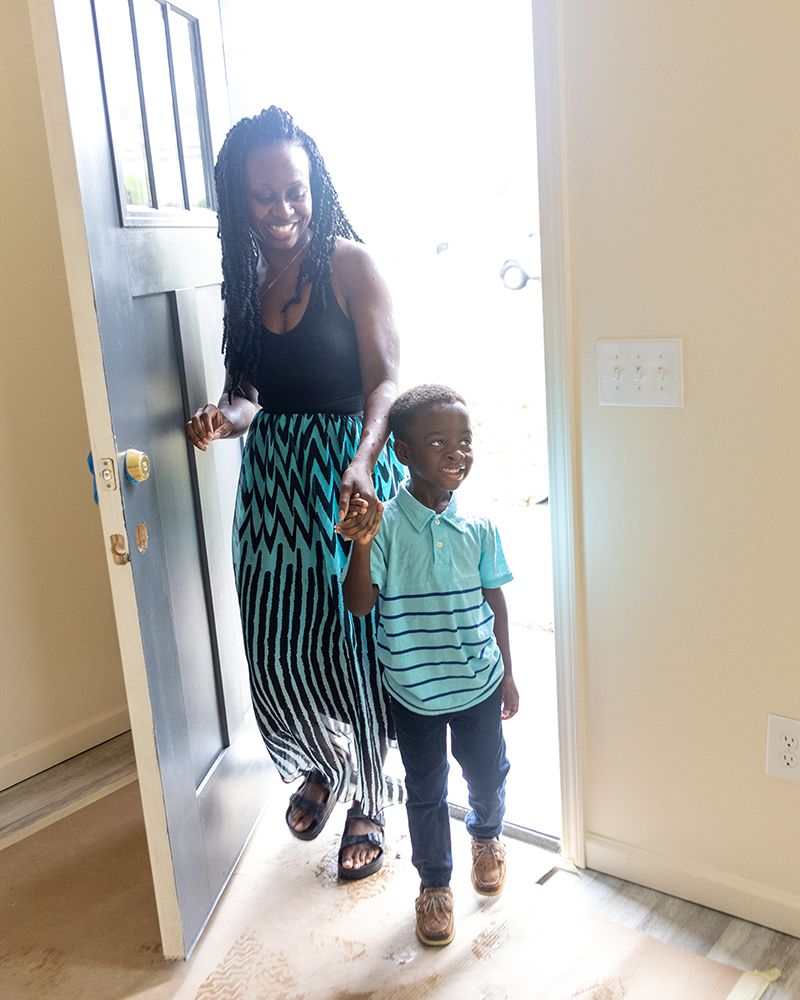 A Black woman and her young son walk into their newly complete Habitat home.