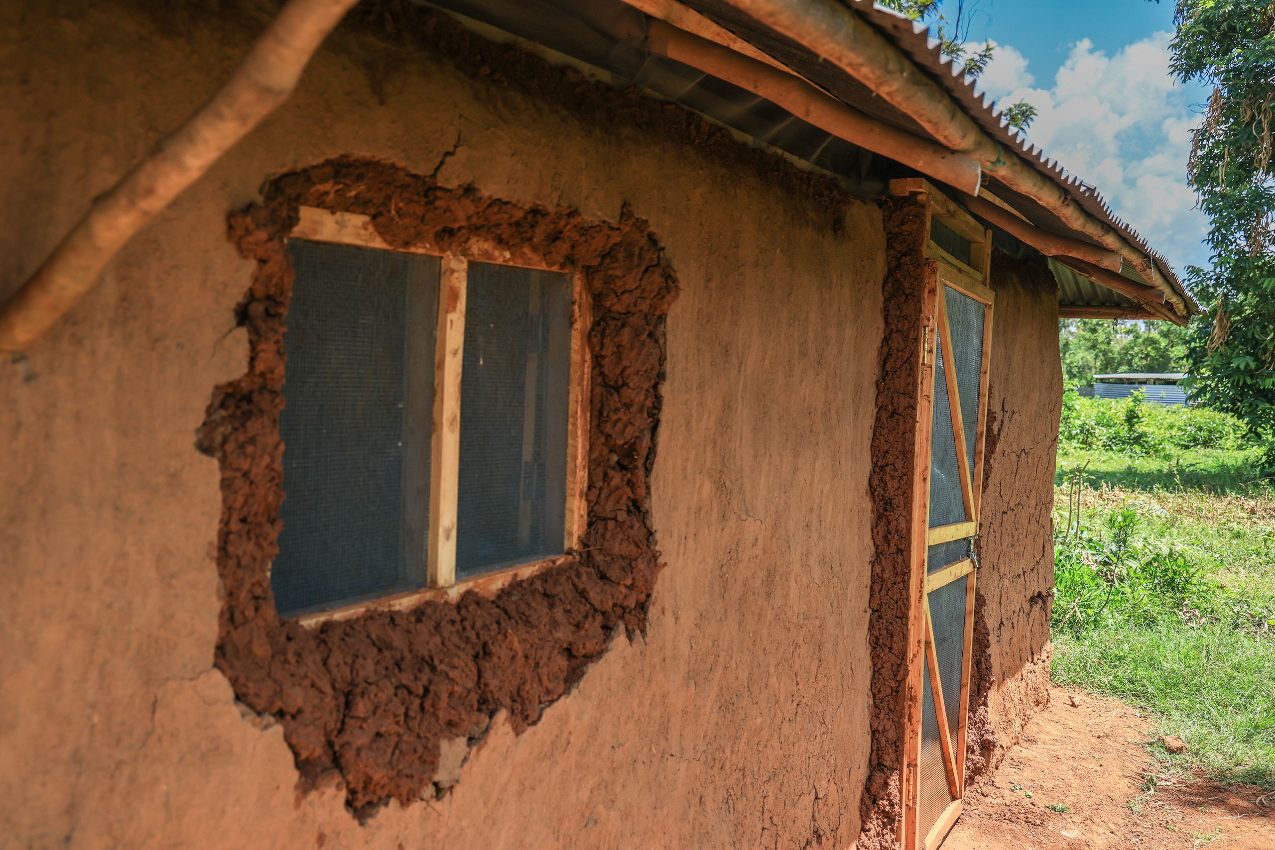 Exterior of a house in Kenya with newly installed mosquito screens on the door and window.