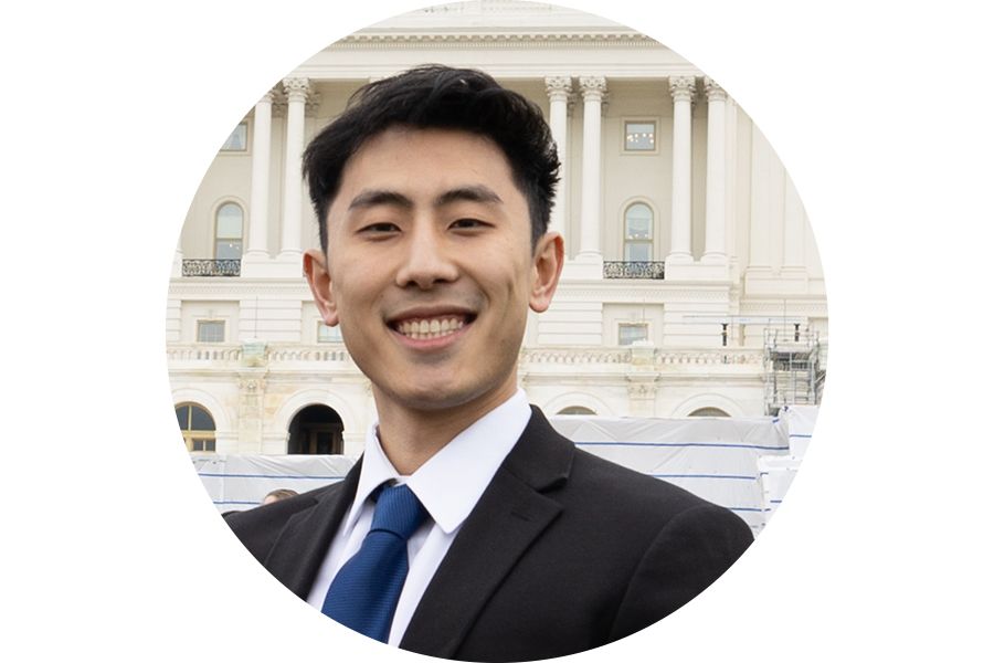 Henry, a young Asian man, stands in front of the U.S. Capitol building during Habitat on the Hill.