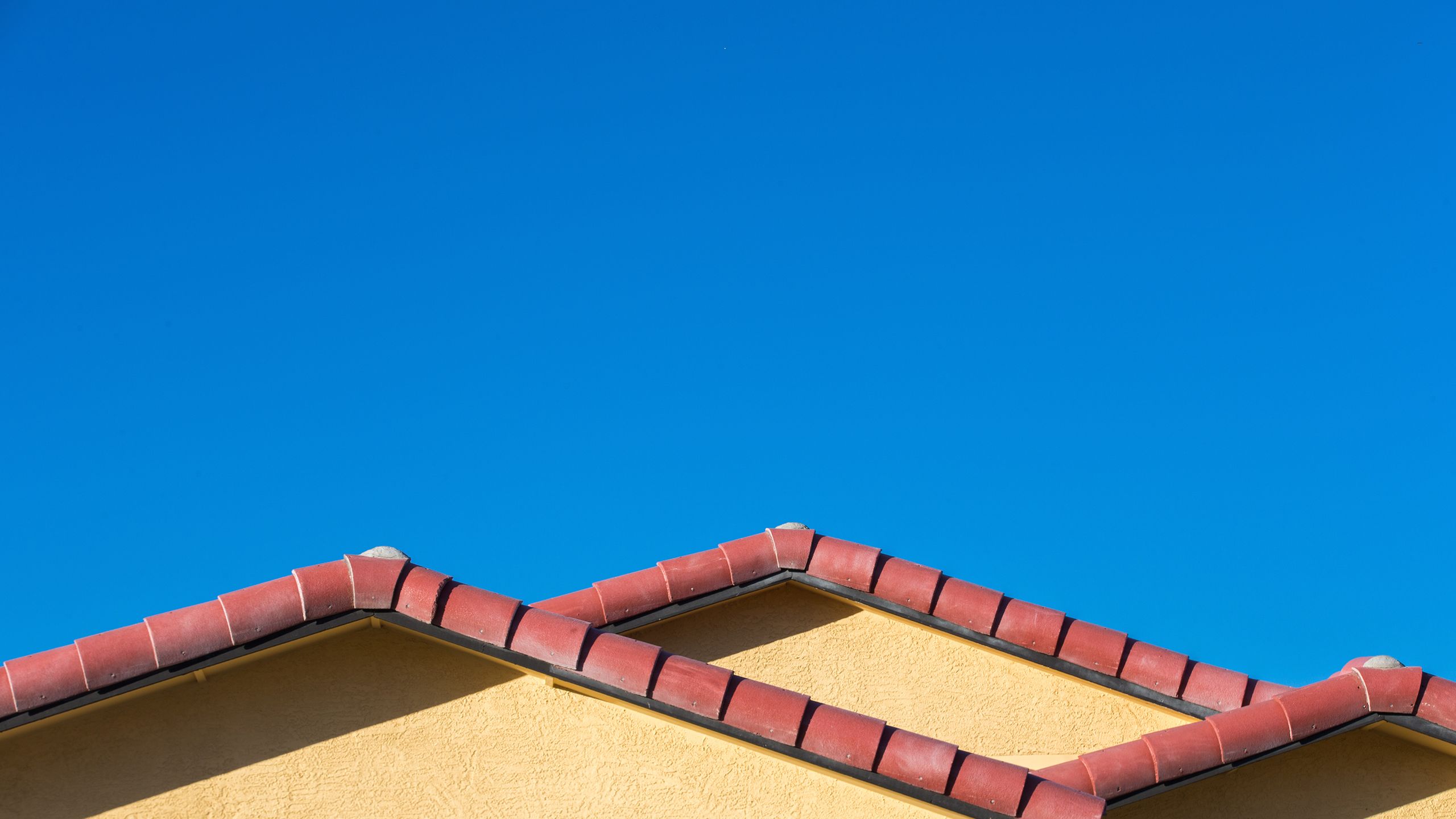 Ceramic tile rooftops on a Habitat house in Arizona against a blue sky