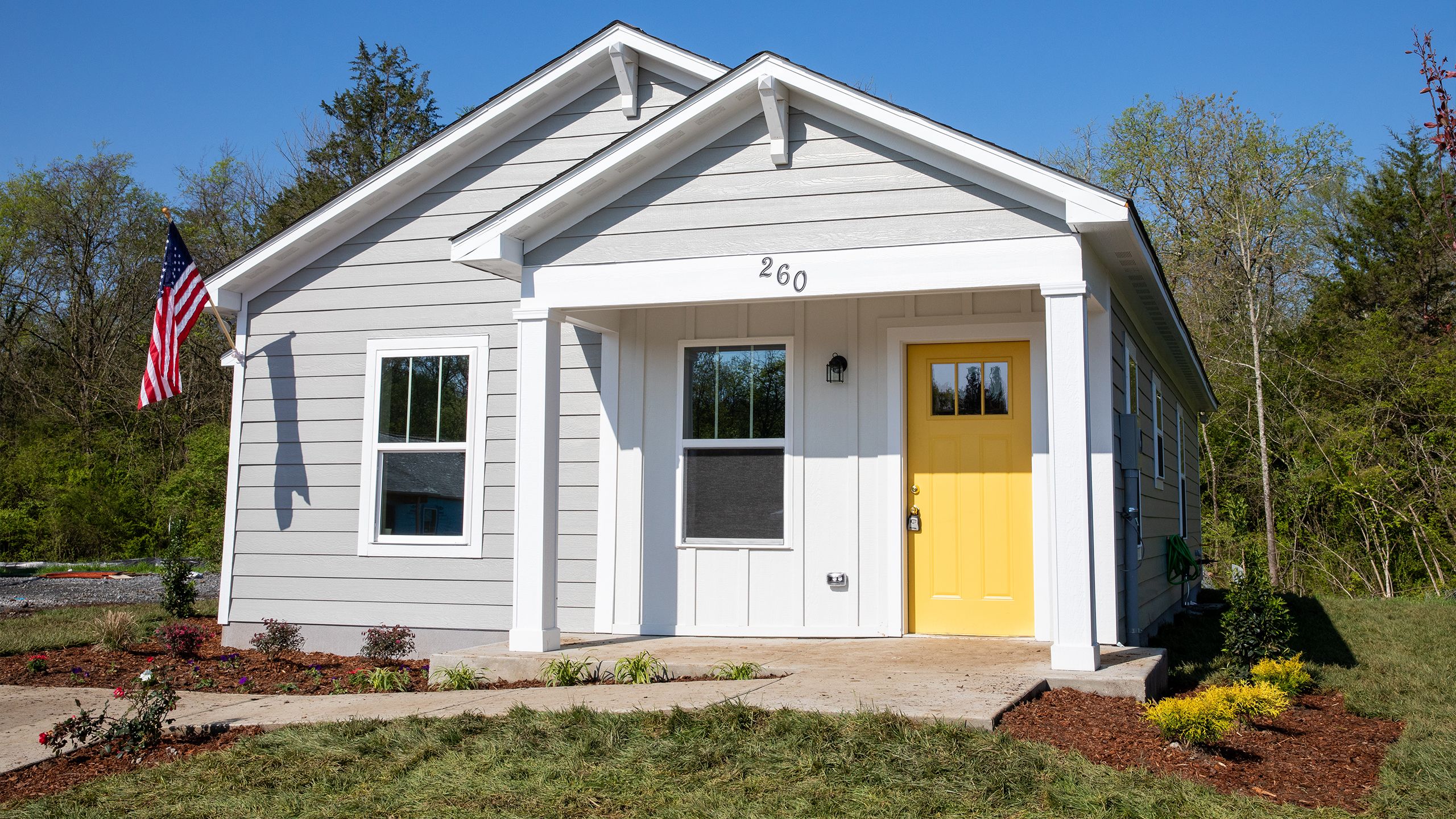 A newly completed Habitat house, with a cheery yellow door at the front porch.
