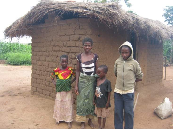 Bertha and her children in front of their old house.