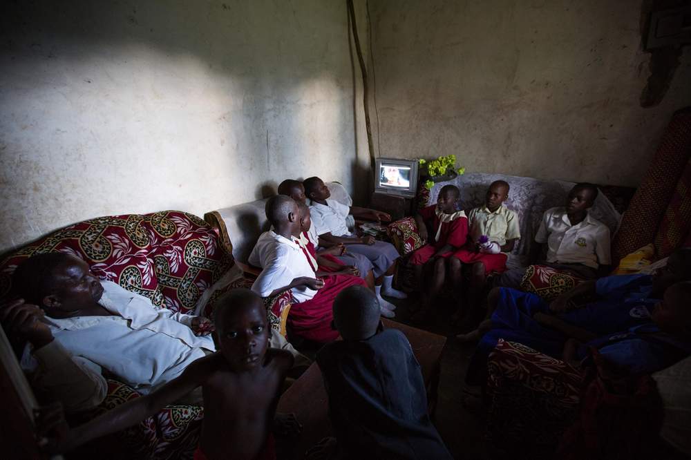 David’s children join him to watch TV in the living room.