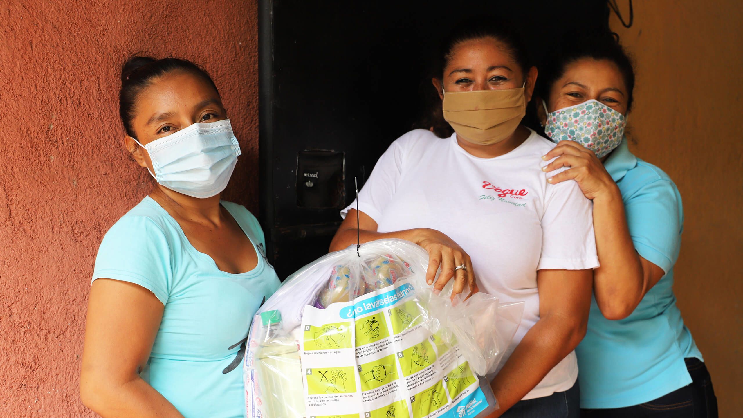 familias y voluntarios construyendo viviendas Hábitat, mujeres recibiendo un kit de higiene durante la pandemia, familias hábitat felices en su vivienda.