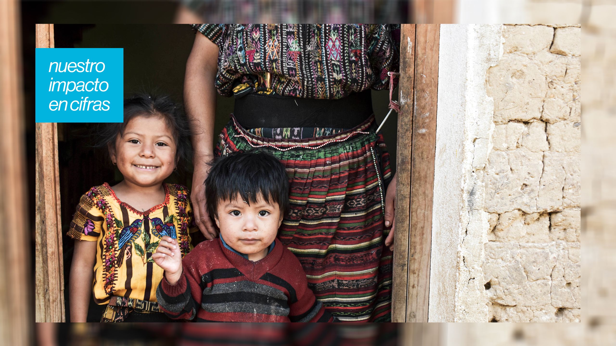 niños guatemaltecos con su mamá en la puerta de su vivienda
