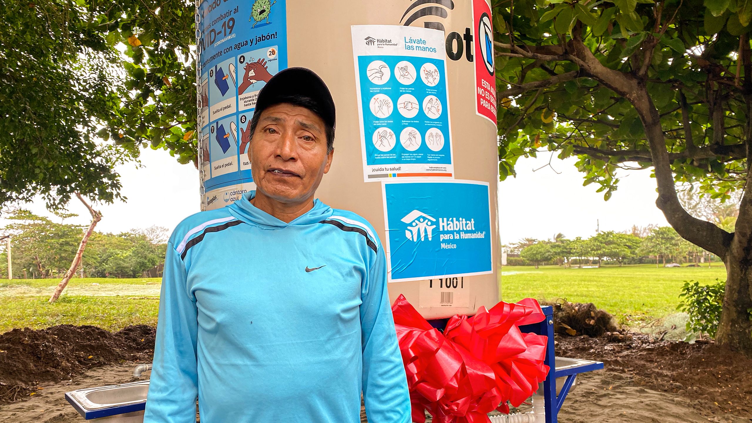 hombre frente al lavamanos público instalado en su comunidad.