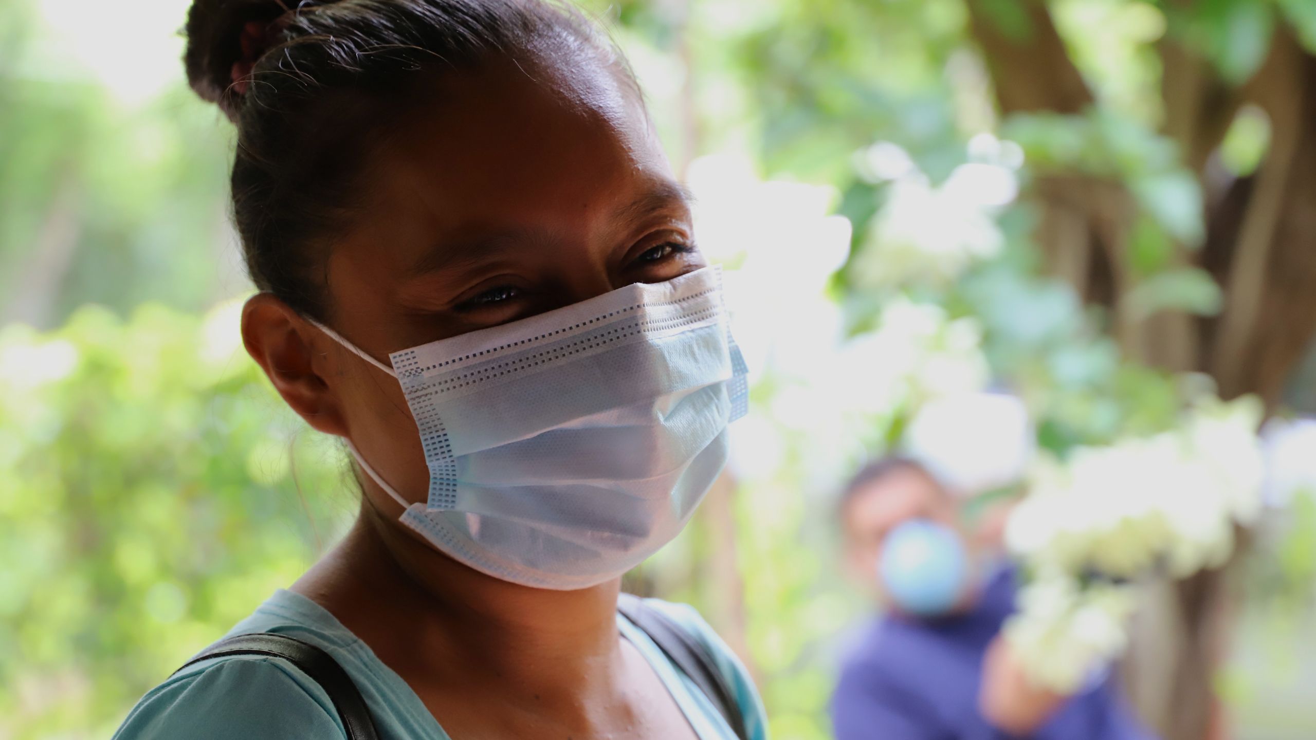 una mujer con mascarilla agradecida por el kit de higiene que se le entregó.