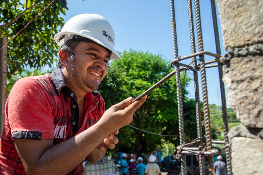 voluntario sonriendo durante la construcción de una casa Hábitat