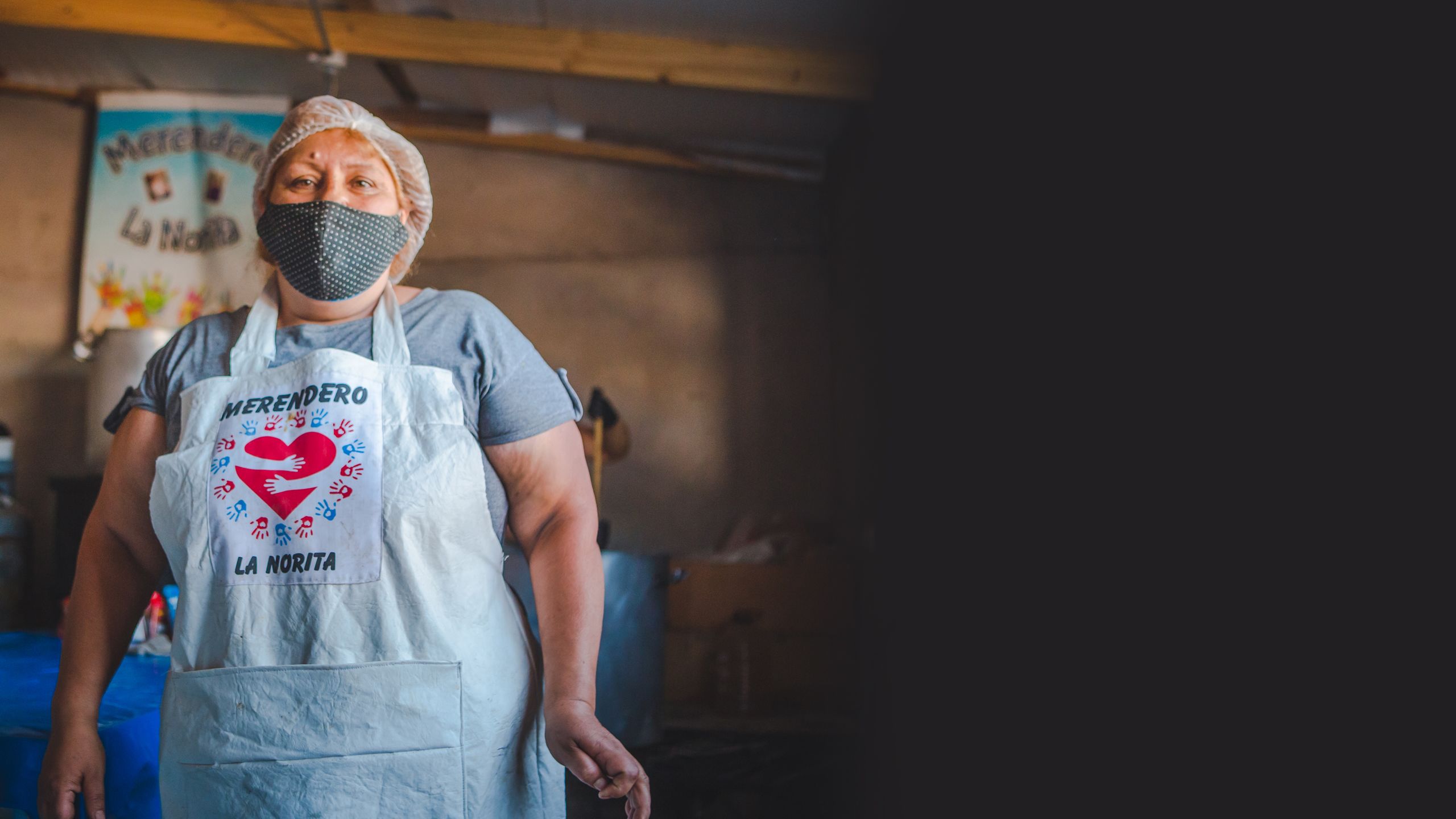 Mujer Argentina posando con delantal y cubreboca.
