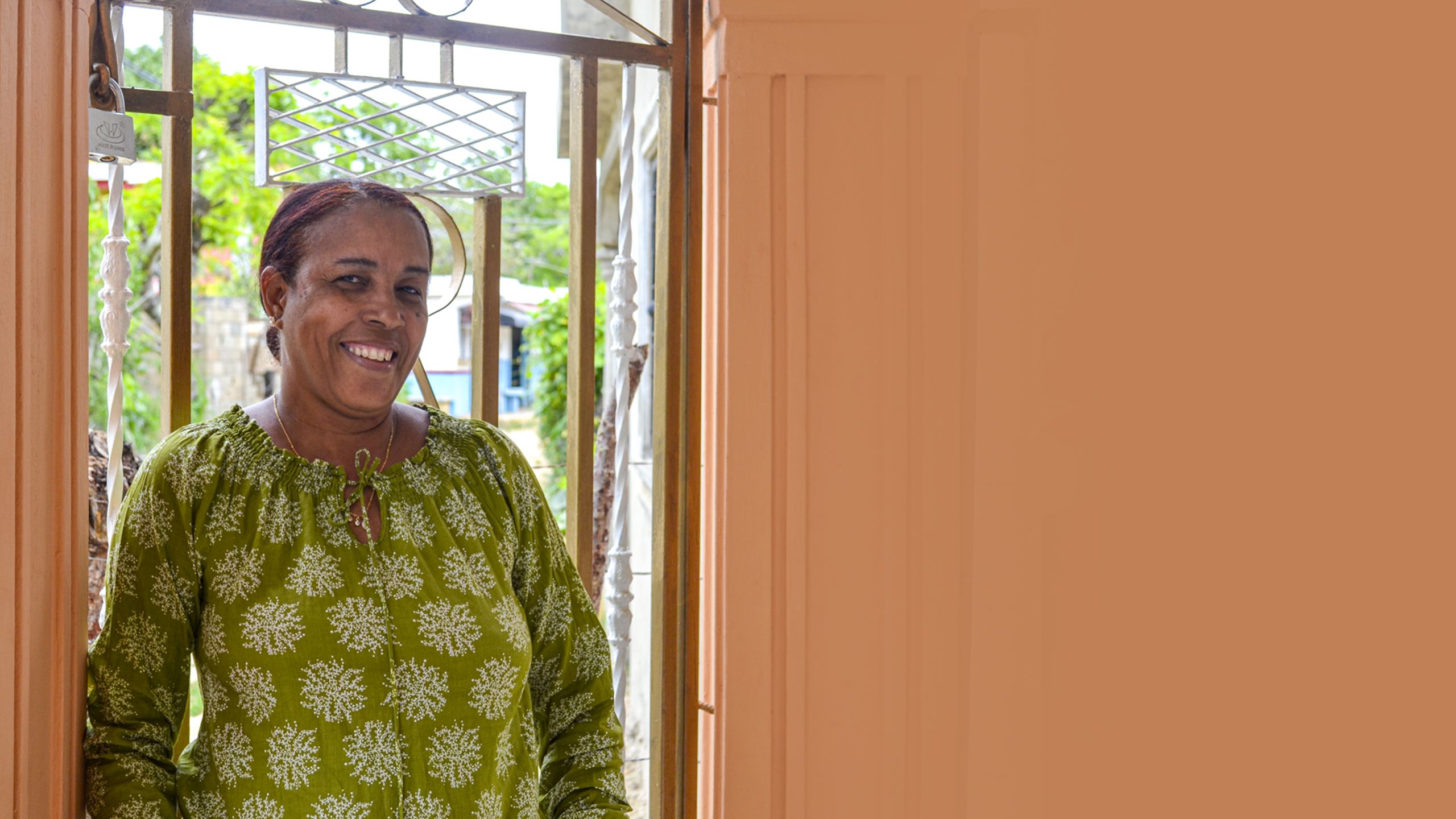 Mujer sonriente entrando a su casa.