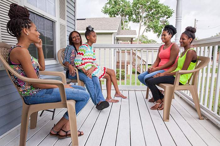 Tracey Davison frequently gathers her daughters on the front porch of their “baby blue house” and reflects on the journey from homelessness to Habitat homeownership.