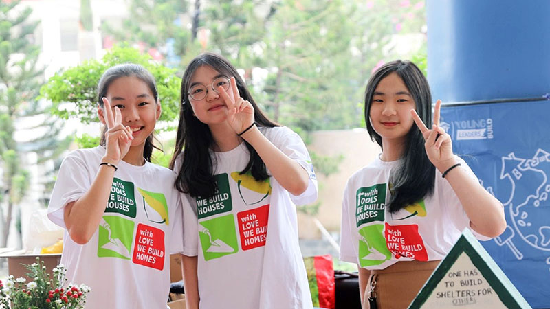 Students from a Habitat school club in Vietnam at a charity sale booth