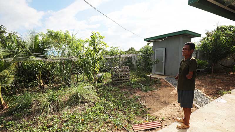 Cambodian homeowner Bunthoeun looking out at his vegetable garden in Kandal province