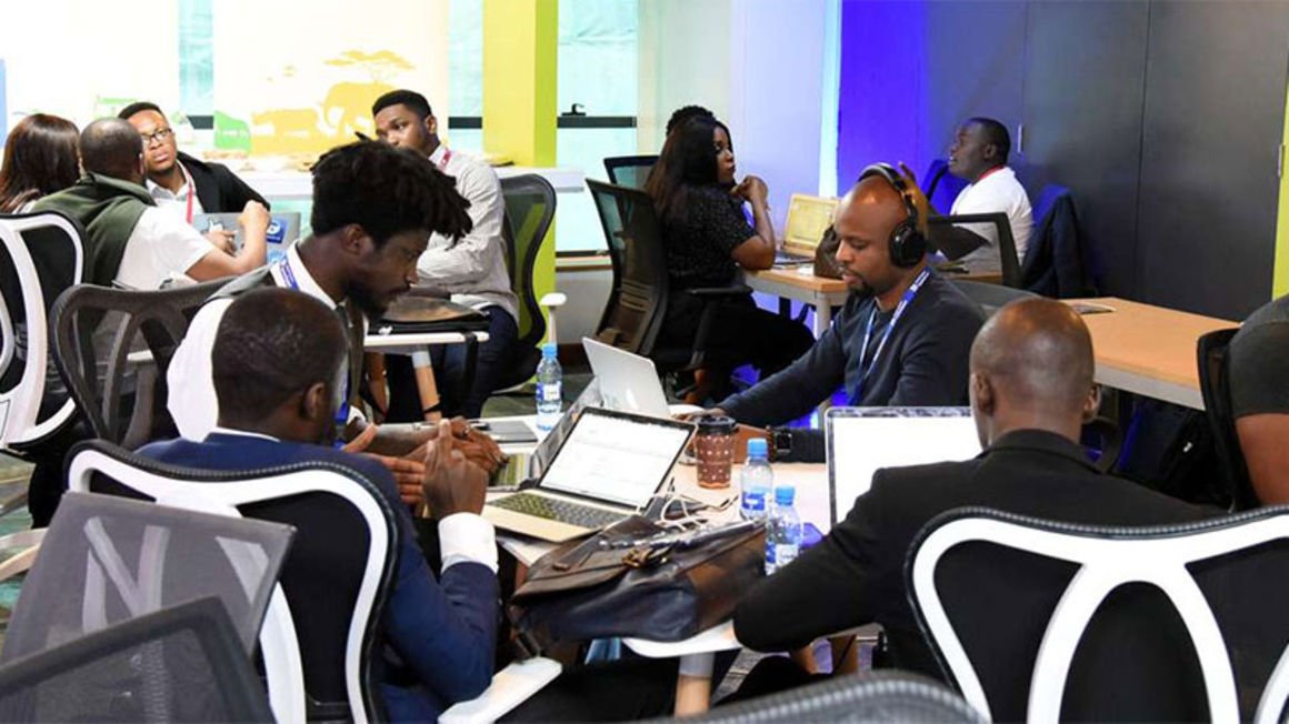 A group of people in a room working on laptops.