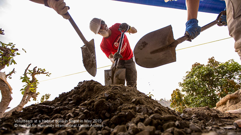 Volunteers shoveling gravel during a May 2019 build in Nepal