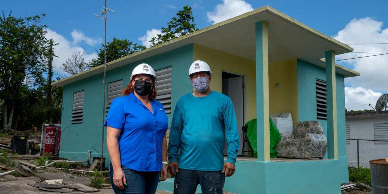 Elizabeth and Javier standing outside a blue home.
