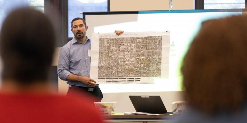 A man presents blueprints.