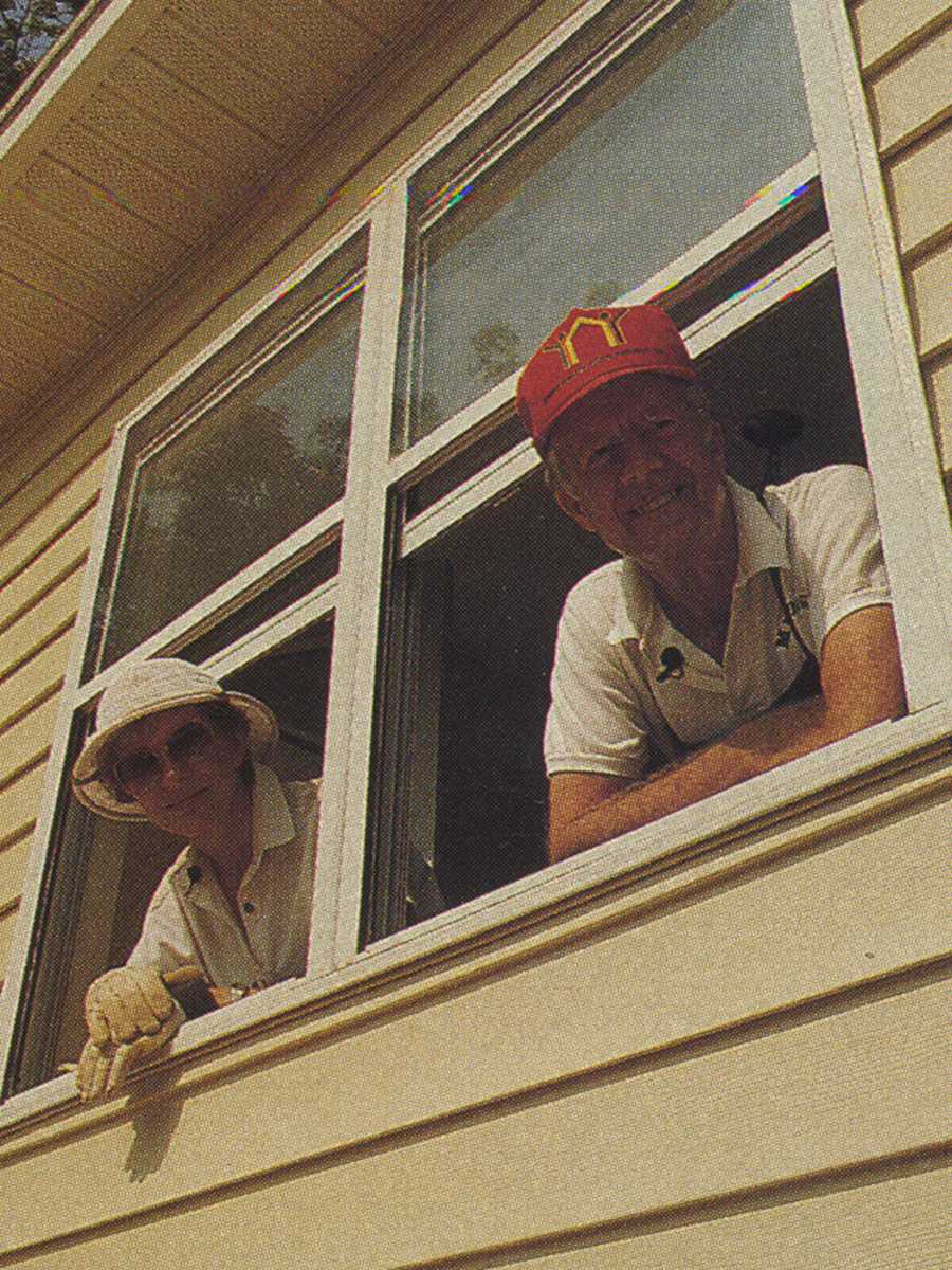 The Carters looking down from a window, smiling. The photo is from 1988.