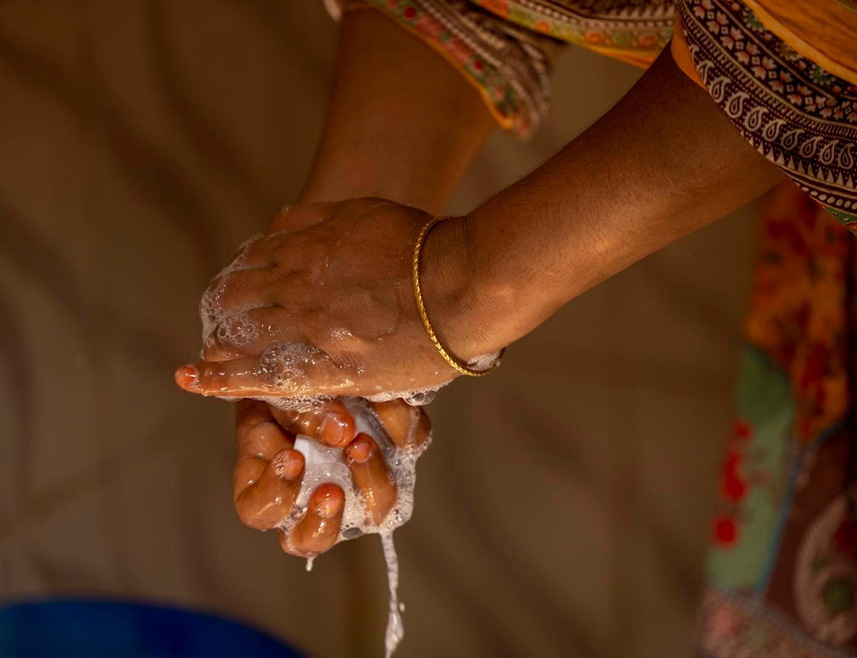 Close-up photo of a woman's hands as she washes her hands with soap.  