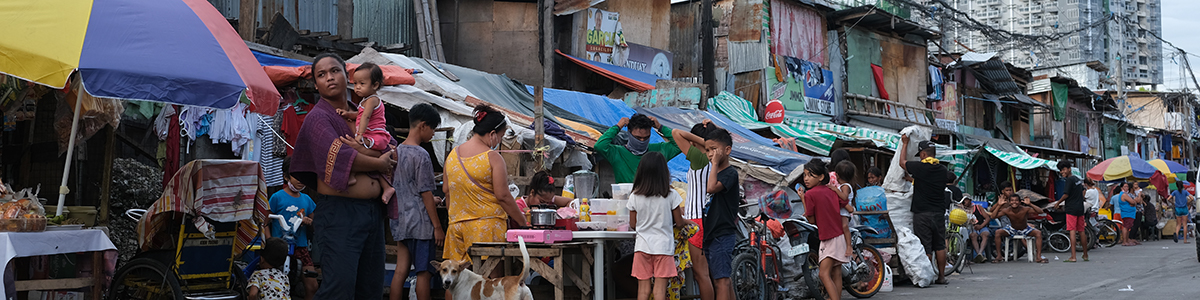 A photo of informal settlement residents shopping and talking at colorful street stands.