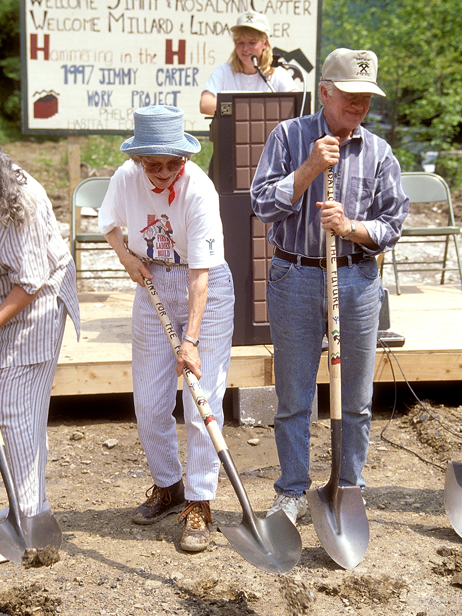 President and Mrs. Carter holding shovels and helping start the build as they dig the foundation.