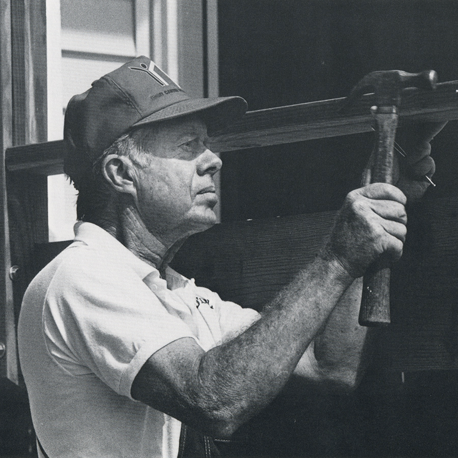 Black and white photo of President Carter hammering.