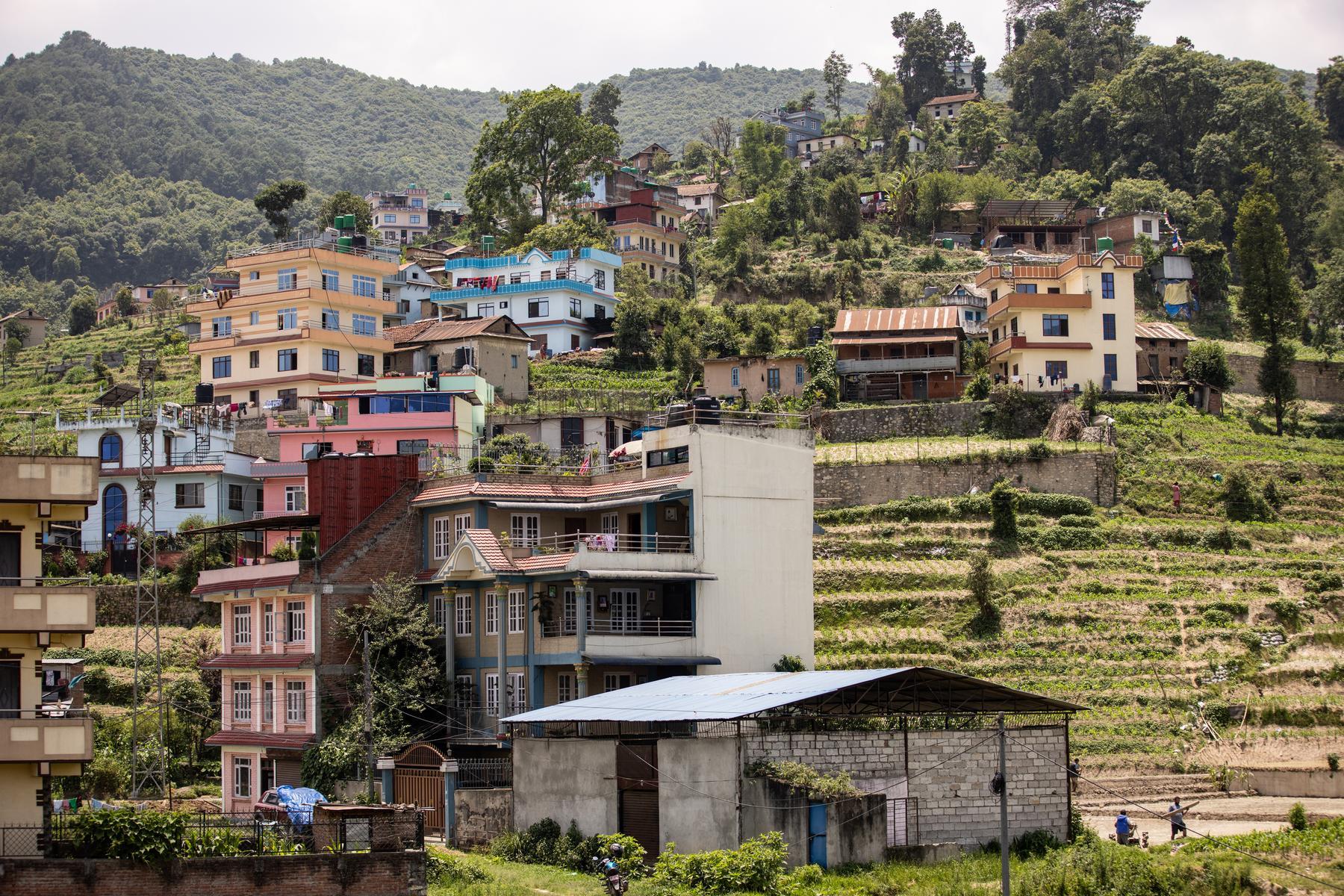 A landscape scene from Nepal showing a hilltop with multiple different types of dwellings.