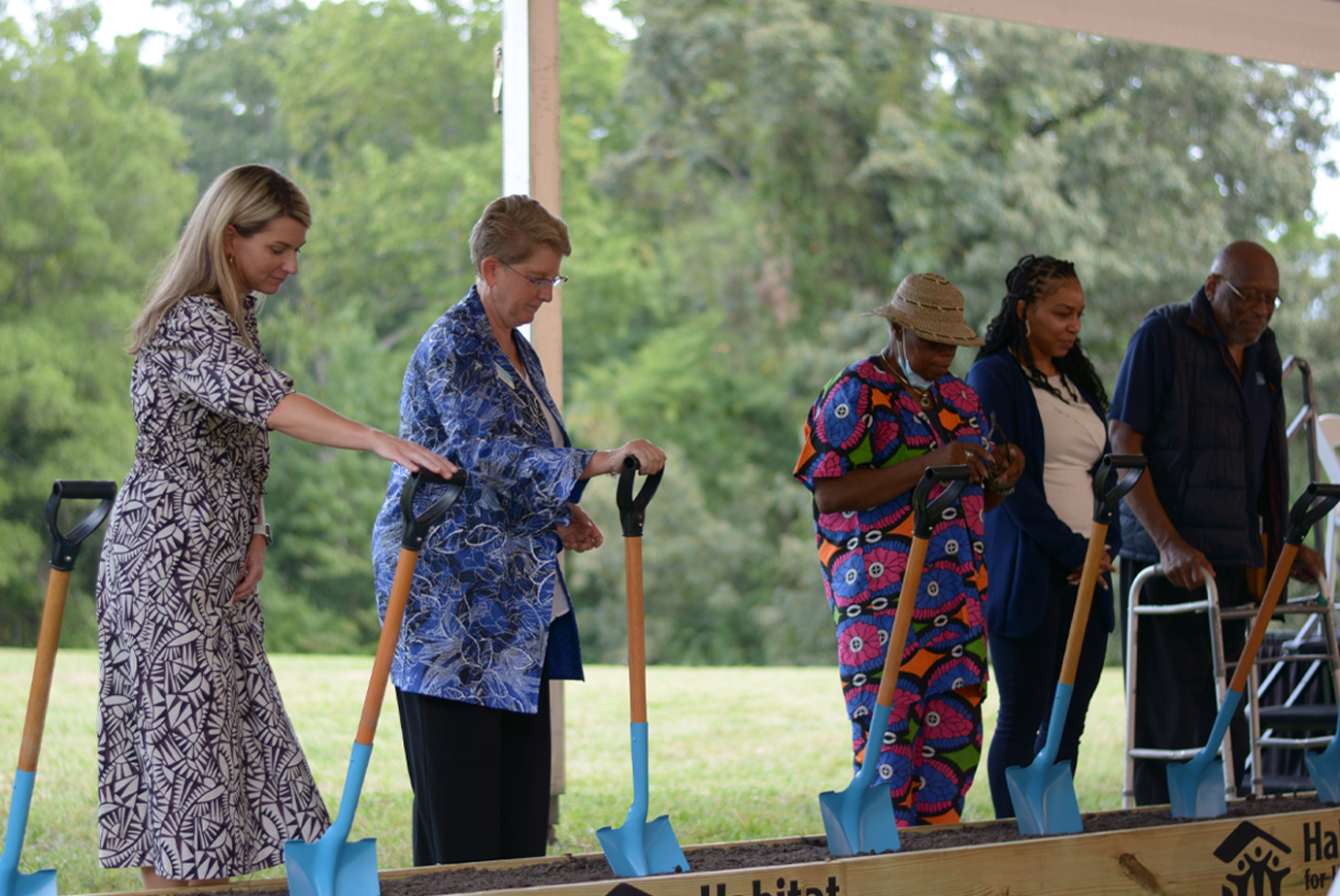 Line of people holding shovels at groundbreaking ceremony