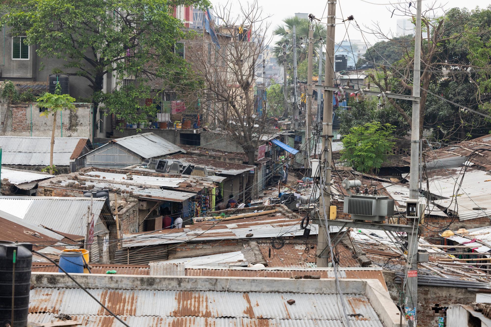 View from above of the Duaripara informal settlement in Dhaka showing rusting metal roofs and makeshift shelters.