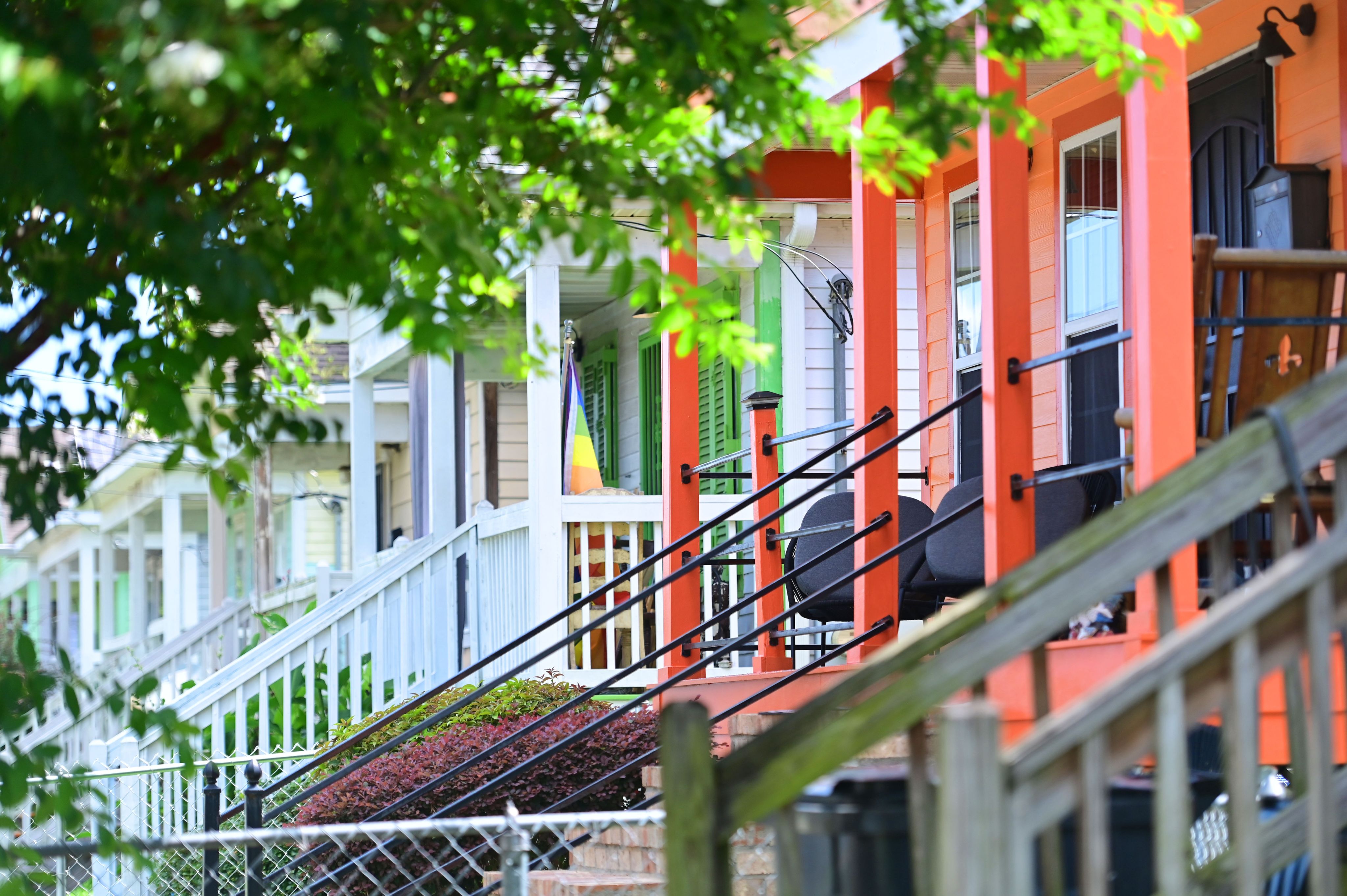 A colorful orange porch in the foreground, with the porches of neighboring houses receding into the distance.