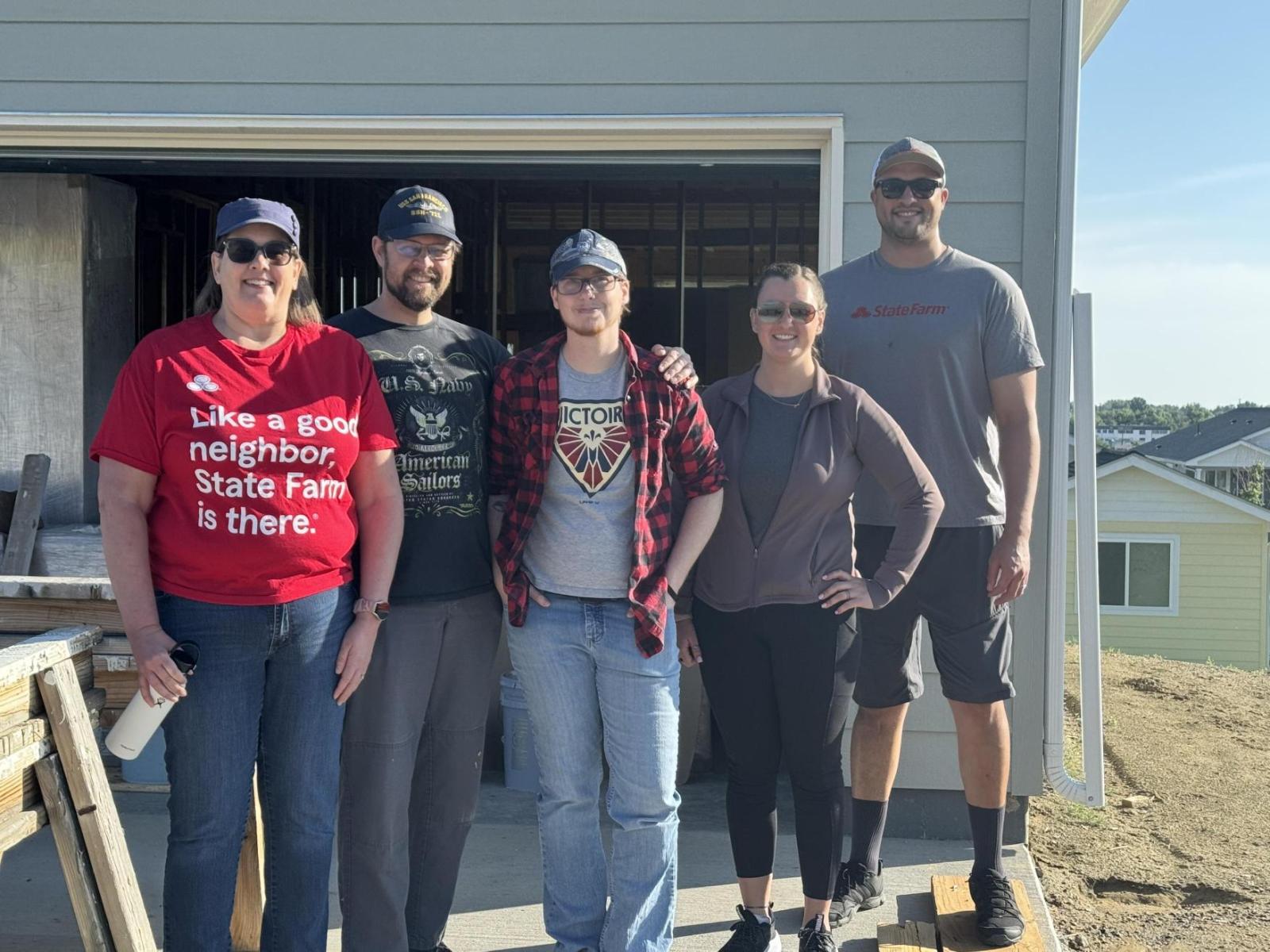 Group of State Farm employees posing in front of a garage.