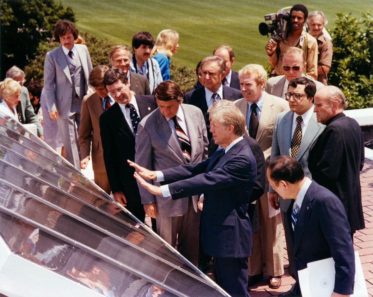 President Carter and others gather next to solar panels for a dedication ceremony. 