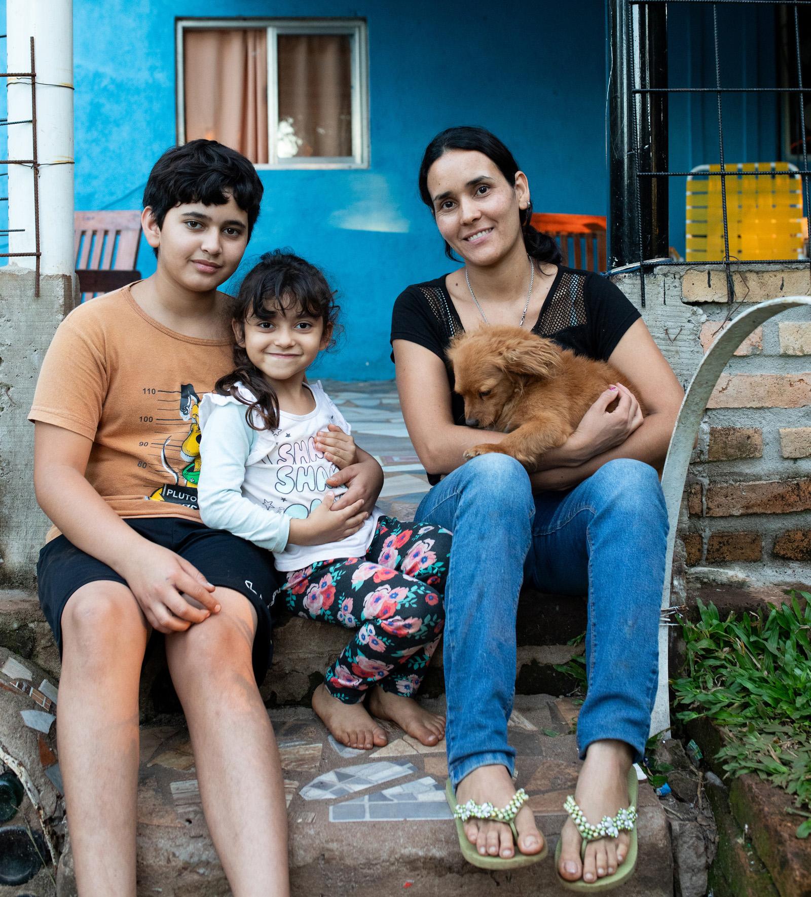 Portrait of Patricia Ferreyra, her daughter Guadalupe (C) and her son Jonathan in front of their house in Campo Viera, Oberá, Misiones.