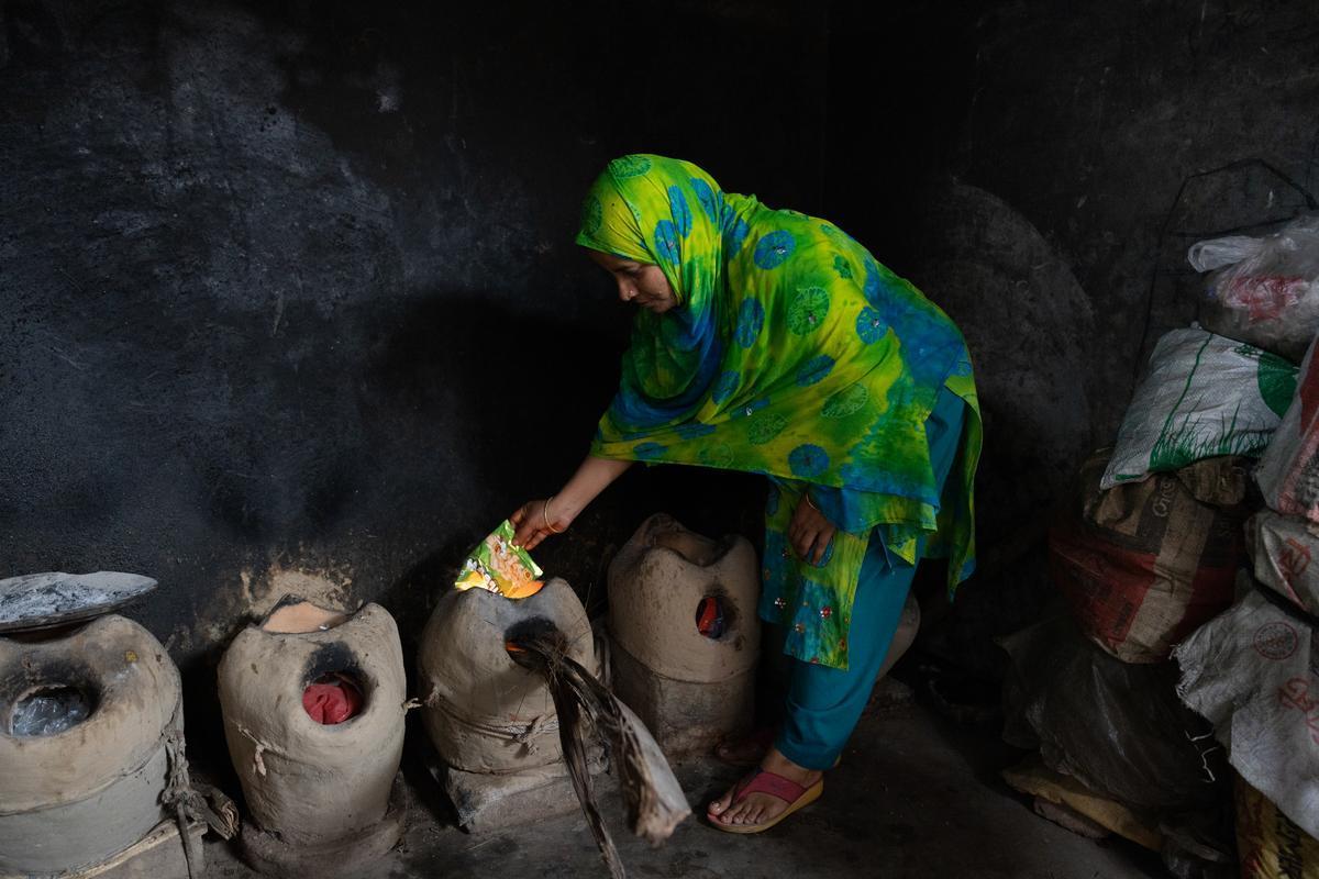 Duaripara informal settlement in Dhaka. Sahana cooks a meal using a cement pot and fire, the customary everyday way to cook in informal settlements in Bangladesh