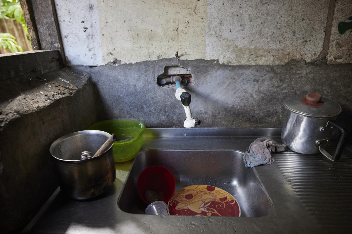 A sink with a water spicket and dishes.