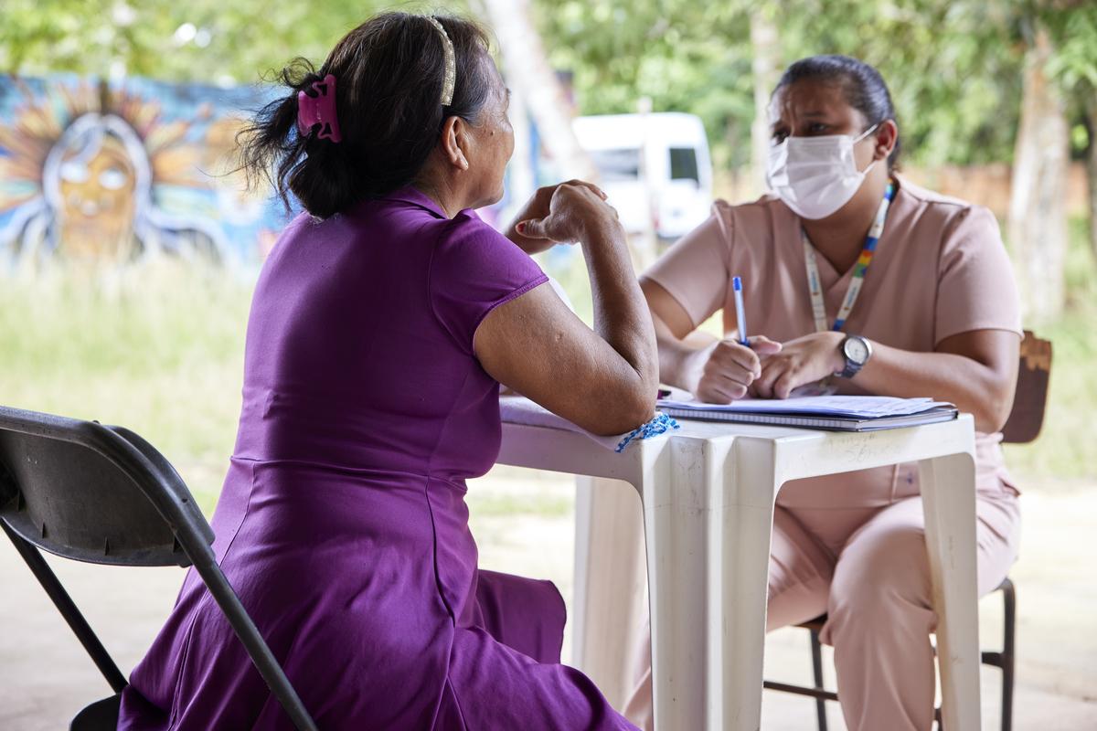Community members, social workers, and nurses at the Maloca (large communal dwelling) dos Povos Indígenas, a multi-use community center in Parque das Tribos.